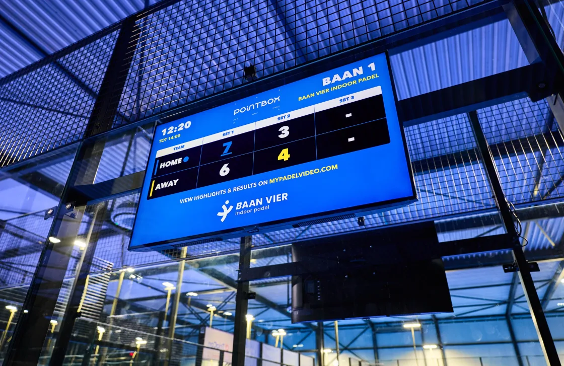 Het 50-inch scorebord toont de live score met het logo van Baan Vier Indoor Padel
